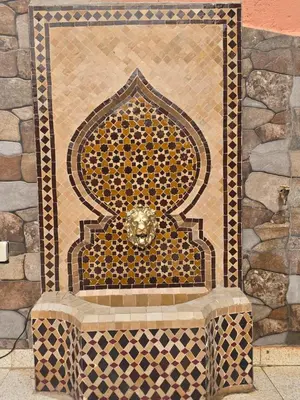 a fountain in front of a stone wall at Riad Miralezia in Marrakech