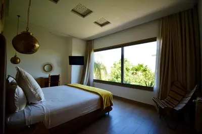 a bedroom with a bed and a large window at Villa MAÙRA Marrakech in Marrakech