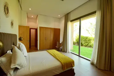 a bedroom with a large bed and a large window at Villa MAÙRA Marrakech in Marrakech
