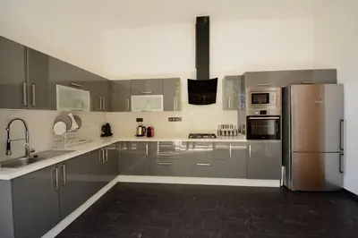 a kitchen with gray cabinets and stainless steel appliances at Villa MAÙRA Marrakech in Marrakech