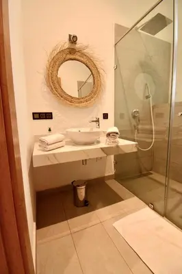 a bathroom with a sink and a glass shower at Villa MAÙRA Marrakech in Marrakech