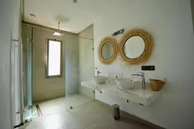 a bathroom with two sinks and a glass shower at Villa MAÙRA Marrakech in Marrakech