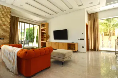 a living room with a couch and a tv at Villa MAÙRA Marrakech in Marrakech