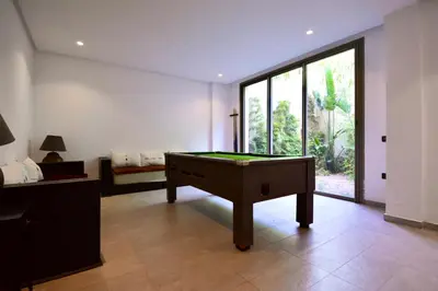 a room with a pool table and a large window at Villa MAÙRA Marrakech in Marrakech