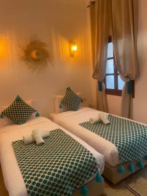 two beds sitting next to each other in a room at Riad dei colori in Marrakech
