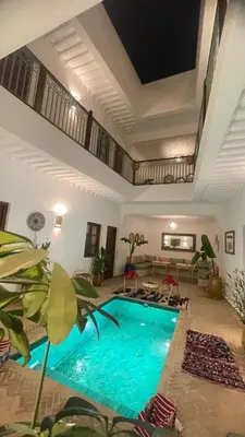 a large swimming pool in a living room at Riad dei colori in Marrakech