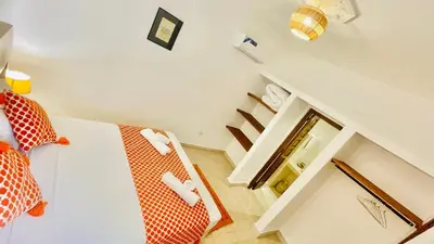 a room with a bed and a mirror and stairs at Riad dei colori in Marrakech
