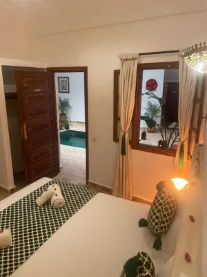a bedroom with a bed and a mirror and a pool at Riad dei colori in Marrakech