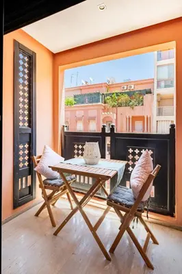 a table and two chairs on a balcony at Magnifique appartement Gueliz in Marrakech