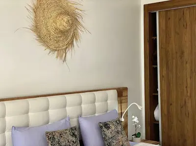 a bedroom with a bed with purple pillows and a wall with a wreath at apparte 2 chambres de luxe en face la gare gueliz in Marrakech