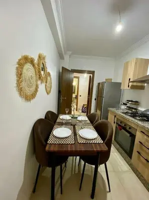 a kitchen with a table with chairs and a tableasteryasteryasteryasteryasteryastery at apparte 2 chambres de luxe en face la gare gueliz in Marrakech
