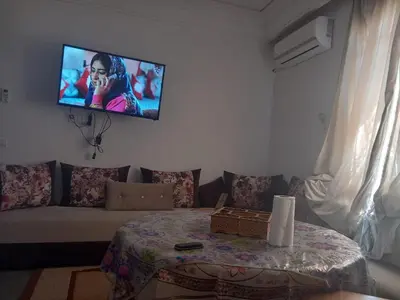 a living room with a couch and a tv on the wall at Apartment - Sleeps up to 8 & parking in Marrakech