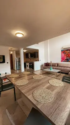 a living room with a large wooden table and a couch at Duplex Jasmine in Marrakech