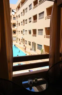 a view of a swimming pool from a hotel window at Appartement de lux in Marrakech