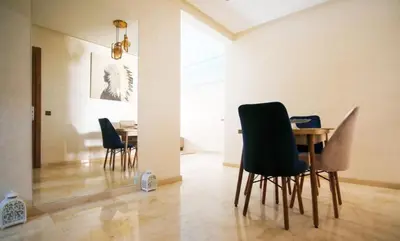 a dining room with a table and chairs at Appartement de lux in Marrakech