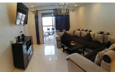 a living room with a couch and a table at Charming Apartment in the Heart of Marrakech - Modern Amenities and Prime Location in Marrakech