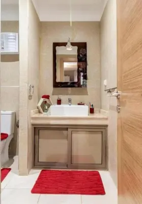 a bathroom with a sink and a red rug at Charming Apartment in the Heart of Marrakech - Modern Amenities and Prime Location in Marrakech