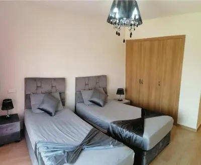 two beds sitting next to each other in a bedroom at Charming Apartment in the Heart of Marrakech - Modern Amenities and Prime Location in Marrakech