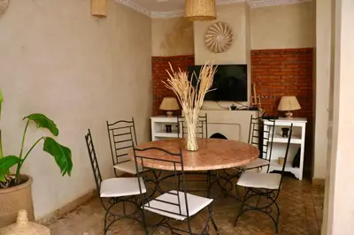 a dining room with a table and chairs and a tv at Riad CHEZ MOI in Marrakech