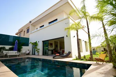 a villa with a swimming pool and a house at Somptueuse Family Villa Cherifa avec piscine chauffée in Marrakech