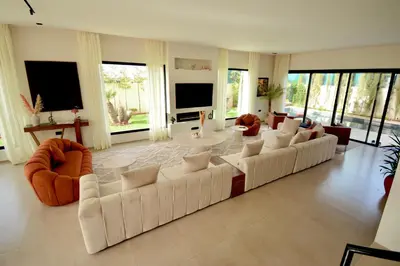 a large living room with a white couch and chairs at Somptueuse Family Villa Cherifa avec piscine chauffée in Marrakech