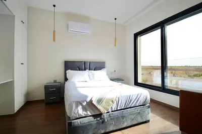a bedroom with a bed and a large window at Somptueuse Family Villa Cherifa avec piscine chauffée in Marrakech