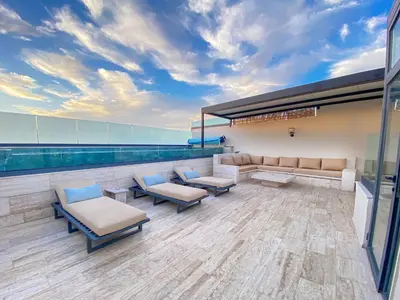 a waiting room with couches and chairs on a building at Triplex de luxe Santorini piscine privée chauffée 3 chambres in Marrakech