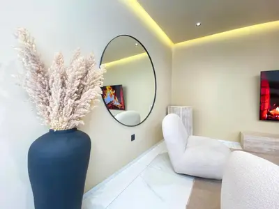 a large blue vase sitting in a living room with a mirror at Triplex de luxe Santorini piscine privée chauffée 3 chambres in Marrakech