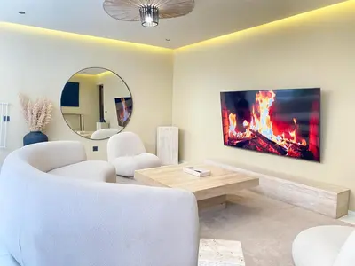 a living room with a white couch and a mirror at Triplex de luxe Santorini piscine privée chauffée 3 chambres in Marrakech