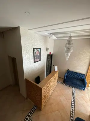 a living room with a blue couch and a chair at L'empreinte Appart Marrakech in Marrakech