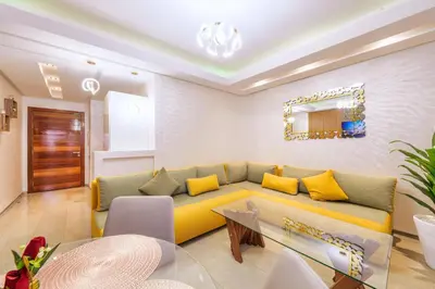 a living room with a yellow couch and a table at Menara garden in Marrakech