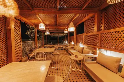 a restaurant with tables and chairs on a balcony at Riad Aslal in Marrakech