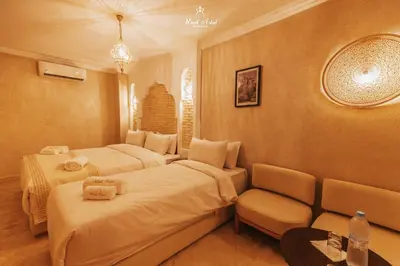 a hotel room with three beds and a couch at Riad Aslal in Marrakech