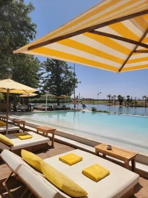 a pool with tables and umbrellas and a swimming pool at les jardins d'atlas waky palm golf in Marrakech