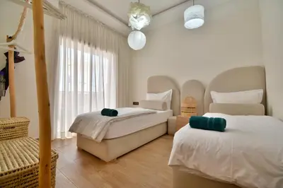 a bedroom with two beds and a window at Superbe appart cosy avec piscine in Marrakech