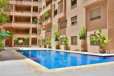 an apartment building with a swimming pool in front of it at Superbe appart cosy avec piscine in Marrakech