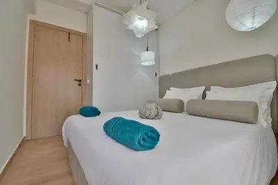a bedroom with a large white bed with blue sheets at Superbe appart cosy avec piscine in Marrakech