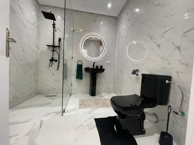 a bathroom with a toilet and a glass shower at Joli appartement hyper centre Guéliz in Marrakech