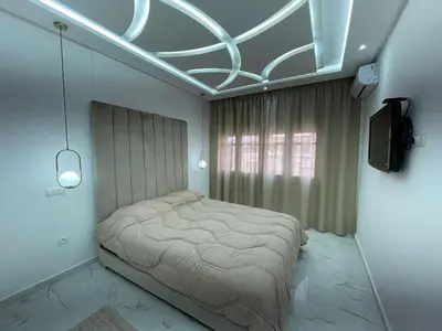 a bedroom with a bed and a tv in it at Joli appartement hyper centre Guéliz in Marrakech