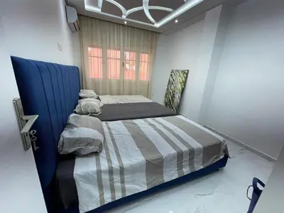 a bedroom with a bed with a blue head board at Joli appartement hyper centre Guéliz in Marrakech