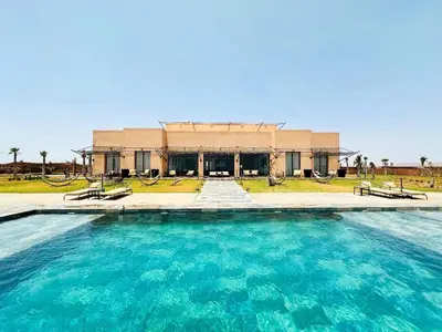 a large pool of water in front of a building at Somptueuse Villa avec Terrains Padel et Foot Piscine Marrakech in Marrakech