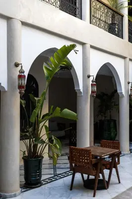 a table and a plant in front of a building at Alrashid Marrakech Boutique Hotel & SPA in Marrakech