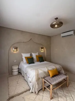 a bedroom with a large bed with yellow and green pillows at Villa Dar AL Manel in Aït Amara