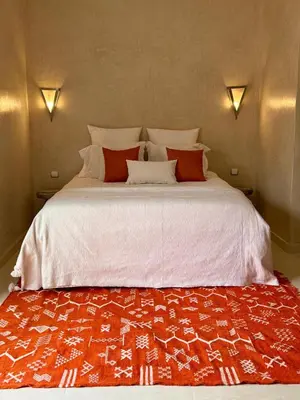 a large bed with red and white sheets and pillows at Villa Dar AL Manel in Aït Amara