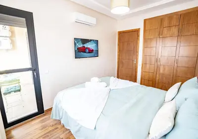 a bedroom with a bed and a couch at Appart Mayar 52 in Marrakech