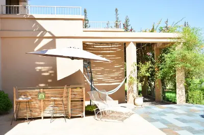 a patio with a table and an umbrella and chairs at Villa Tulum - Indoor Spa & Pools in Marrakech