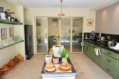a kitchen with green cabinets and plants on a table at Villa Tulum - Indoor Spa & Pools in Marrakech