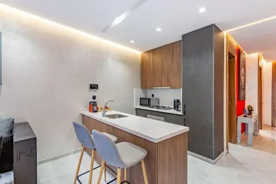 a kitchen with two bar stools and a counter top at New ! Bright And Comfortable App in city center in Marrakech