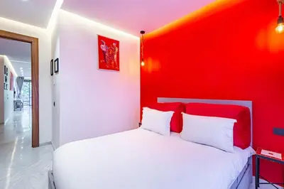 a bedroom with a white bed with a red wall at New ! Bright And Comfortable App in city center in Marrakech