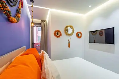 a bedroom with a bed with orange pillows and mirrors at New ! Bright And Comfortable App in city center in Marrakech